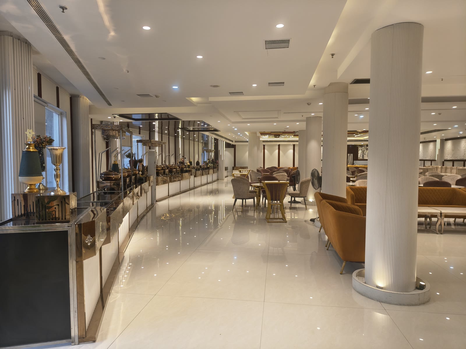 Grand pillar-free air-conditioned banquet hall interior with marble flooring and golden chandeliers at Katani's Sunny Club Kharar